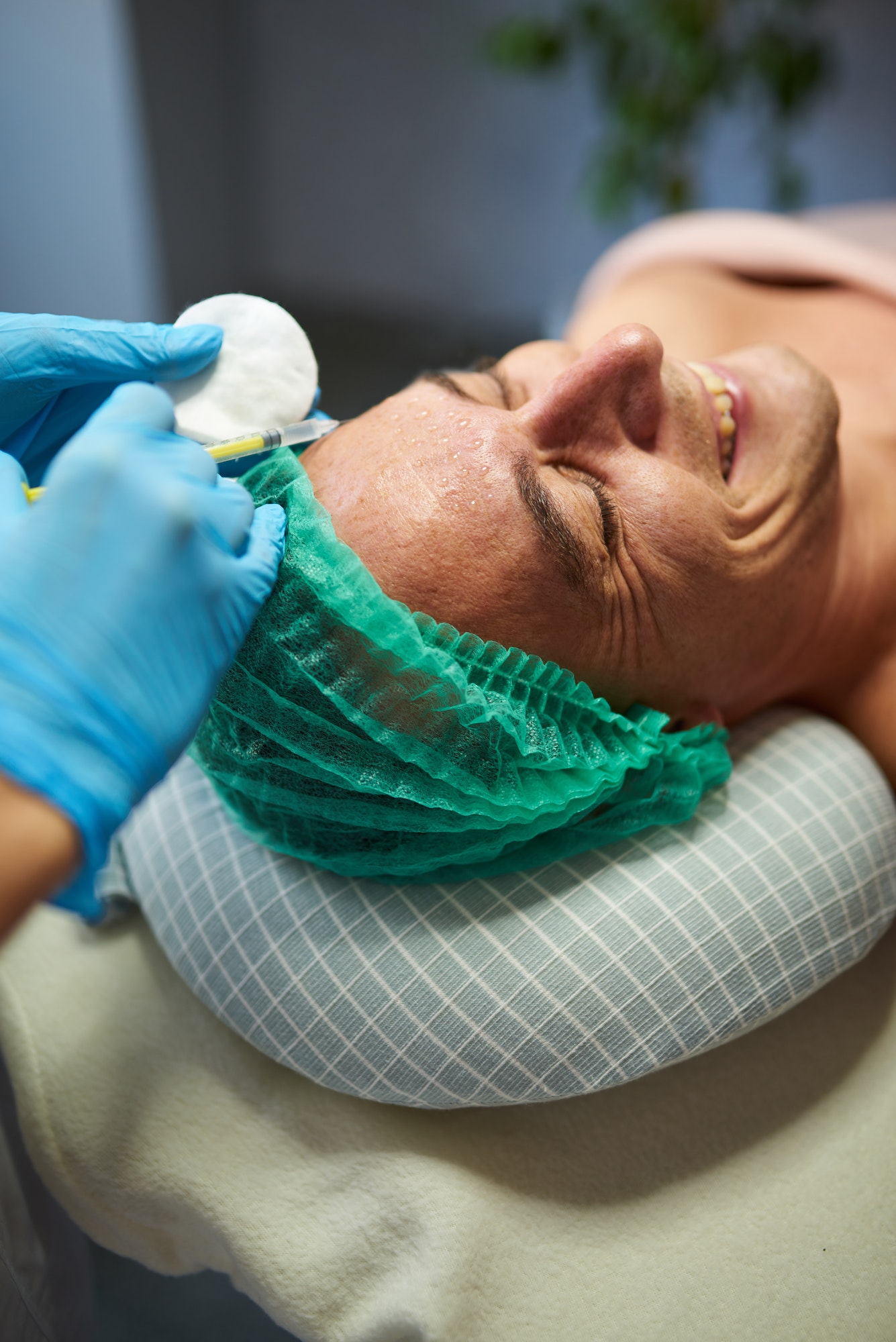 Smiling man receiving cosmetological procedure